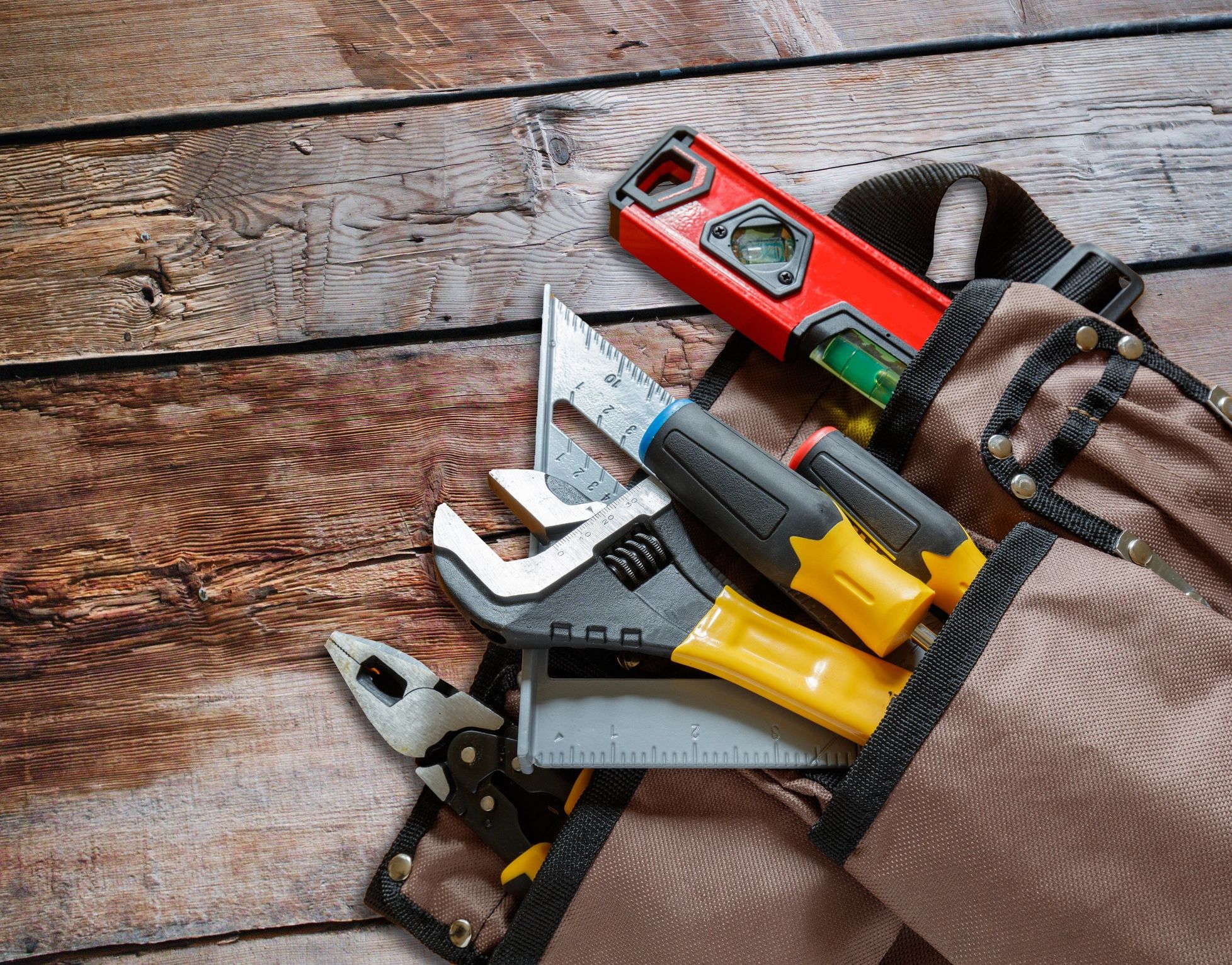 Contractor tools and consumables arranged on wood surface