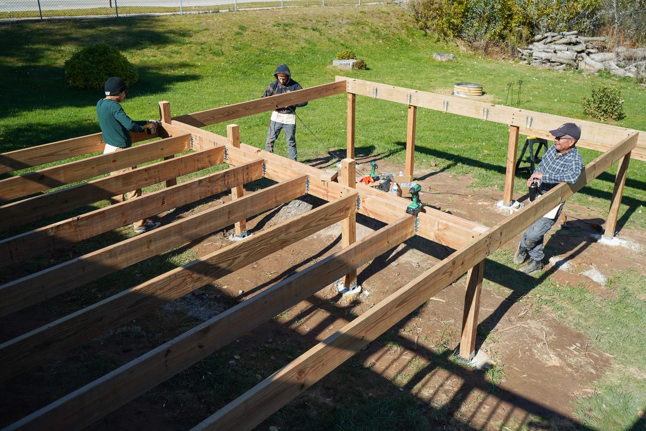 Contractors building a deck with framing tools